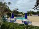 Community pool with blue umbrellas, lounge chairs, and tables at 2200 San Christabolo Dr # 106, Kissimmee, FL 34741