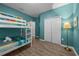 Bunk beds and a dresser in a bedroom with teal walls and wood-look floors at 2612 Yountville Ave, Kissimmee, FL 34741