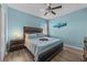 Bedroom with wood bed frame, light blue walls, and ceiling fan at 2612 Yountville Ave, Kissimmee, FL 34741