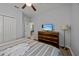 Striped bedding, dresser, and TV in a bedroom with wood-look floors at 2612 Yountville Ave, Kissimmee, FL 34741