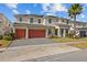 Two-story house with three-car garage and orange doors at 2612 Yountville Ave, Kissimmee, FL 34741