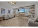 Spacious living room with wood-look floors and a large TV at 2612 Yountville Ave, Kissimmee, FL 34741