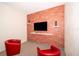 Relaxing sitting area with two red armchairs and a brick accent wall at 2746 Bookmark Dr, Kissimmee, FL 34746