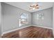 Bedroom with wood-look floors, ceiling fan, and window with blinds at 3231 Avenue M Nw, Winter Haven, FL 33881