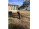 Backyard with overgrown grass and a damaged tree stump at 34429 Laralack Ave, Leesburg, FL 34788