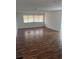 Spacious living room with wood-look floors and large windows at 34429 Laralack Ave, Leesburg, FL 34788