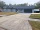 Cozy one-story home featuring a gray exterior, black garage door, and spacious driveway at 4749 Hopespring Dr, Orlando, FL 32829
