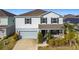 Two-story house with gray siding, stone accents, and a two-car garage at 583 Taft Dr, Davenport, FL 33837