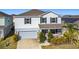 Two-story house with gray siding, stone accents, and a two-car garage at 583 Taft Dr, Davenport, FL 33837