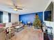 Living room with L-shaped sofa, Christmas tree, and blue accent wall at 583 Taft Dr, Davenport, FL 33837