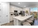 Spacious kitchen with white cabinets, stainless steel appliances, and a large island with seating at 8178 Coconut Pl, Kissimmee, FL 34747