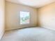 Bright bedroom features carpet and a large window at 880 Spinnaker Way, Kissimmee, FL 34746