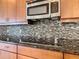 Close-up of kitchen backsplash with modern mosaic tile and stainless steel microwave at 880 Spinnaker Way, Kissimmee, FL 34746