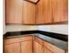 Corner view of kitchen with dark granite countertop and wood cabinets at 880 Spinnaker Way, Kissimmee, FL 34746