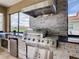 Luxury outdoor kitchen with stainless steel appliances and stonework at 880 Spinnaker Way, Kissimmee, FL 34746