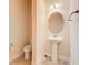Elegant powder room with pedestal sink and round mirror at 880 Spinnaker Way, Kissimmee, FL 34746