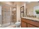 Bathroom with shower, granite countertop, and wood cabinets at 8963 Coco Palm Rd, Kissimmee, FL 34747