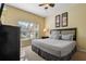King-size bed, large window, dresser, and ceiling fan in this spacious bedroom at 8963 Coco Palm Rd, Kissimmee, FL 34747