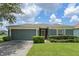 One-story house with a green garage door and manicured lawn at 102 Circle Hill Rd, Sanford, FL 32773