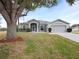 One-story house with a two-car garage and mature landscaping at 103 Vega Ct, Davenport, FL 33896