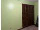 Bedroom with light green walls and double door closet at 1085 Old Hickory Tree Rd, St Cloud, FL 34771