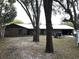 Brick ranch house with mature trees, a large yard, and a metal roof at 1085 Old Hickory Tree Rd, St Cloud, FL 34771