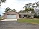 Pink single story home with a white garage door and landscaped yard at 1186 Laguna Cir, St Cloud, FL 34771