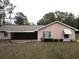 Single story home with pink stucco exterior and landscaping at 1186 Laguna Cir, St Cloud, FL 34771