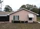 Single story home with pink stucco exterior and landscaping at 1186 Laguna Cir, St Cloud, FL 34771
