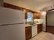 Kitchen boasts wood cabinets, white appliances, and a window view at 1186 Laguna Cir, St Cloud, FL 34771