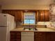 Kitchen with wood cabinets, a double sink, and a window view at 1186 Laguna Cir, St Cloud, FL 34771