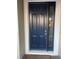 Front door entrance with a navy blue door and sidelights at 14429 Wabasso Loop, Winter Garden, FL 34787