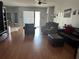Spacious living room with hardwood floors, comfy seating, and sliding doors at 148 Joewood Trl, Davenport, FL 33837