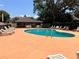 Community pool with lounge chairs, and a screened in pool house, surrounded by trees at 148 Joewood Trl, Davenport, FL 33837