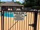 Community pool locked with a gate with sign with pool rules at 148 Joewood Trl, Davenport, FL 33837