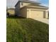 Attached two-car garage with driveway and landscaping at 15043 Pigeon Plum Ln, Winter Garden, FL 34787
