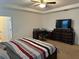 Main bedroom with king bed, dresser, and work area at 15043 Pigeon Plum Ln, Winter Garden, FL 34787