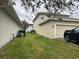 Side yard with landscaping, AC units and partial view of garage at 15043 Pigeon Plum Ln, Winter Garden, FL 34787