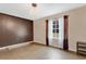 Bedroom with dark brown accent wall, chandelier, and large window at 1960 Murray Rd, Fort Meade, FL 33841