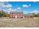 Two-story brick home with a large yard and a partly cloudy sky at 1960 Murray Rd, Fort Meade, FL 33841