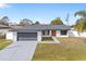 Newly renovated home with gray garage door and orange front door at 202 Cobalt Dr, Kissimmee, FL 34758