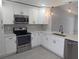 Modern kitchen featuring stainless steel appliances, white cabinets, and light countertops at 202 Cobalt Dr, Kissimmee, FL 34758