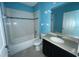 Bathroom with single vanity, tub/shower combo, and teal walls at 228 Whispering Pines Way, Davenport, FL 33837