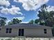 Back of a one-story house featuring a dark roof and sliding glass door at 2531 Buena Vista Dr, Deland, FL 32724