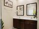 Bright bathroom features a double vanity with modern fixtures and framed mirrors at 2717 Coupe St, Kissimmee, FL 34746