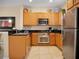 Bright kitchen featuring stainless steel appliances, tan cabinets, and stylish decor at 2717 Coupe St, Kissimmee, FL 34746