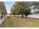 Backyard view showcasing a grassy area, a privacy fence, and mature trees at 2717 Shelby Ruth Pl, St Cloud, FL 34769