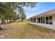 Side yard with a walkway, grassy area, and partial view of the house and other homes at 2717 Shelby Ruth Pl, St Cloud, FL 34769