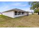 Rear view of the house, featuring a large enclosed patio and a grassy backyard at 2717 Shelby Ruth Pl, St Cloud, FL 34769