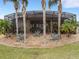 House exterior showcasing a large screened patio area with tropical landscaping at 296 Del Sol Ave, Davenport, FL 33837